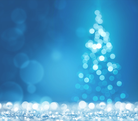 Blue light and christmas tree on white defocused sparkles