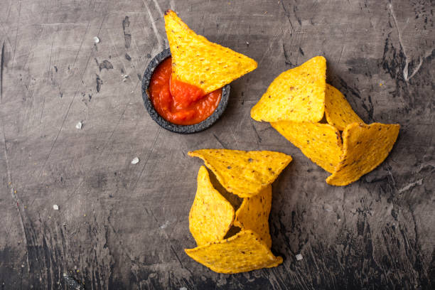 istock Tortilla Corn Chips or Nachos with sauce in a black bowl, on a dark background 1076224424