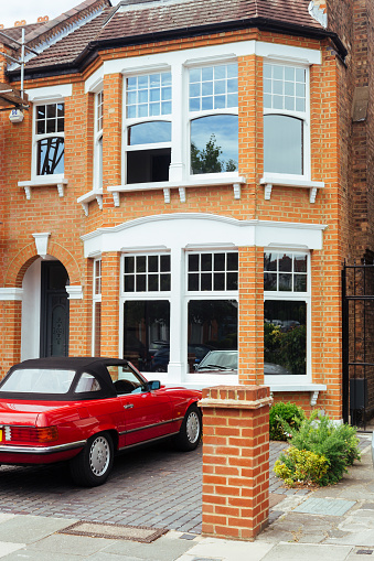 London/UK - July 21 2018: modern Britain Terraced House with red Mercedes parked in front of it in London, UK