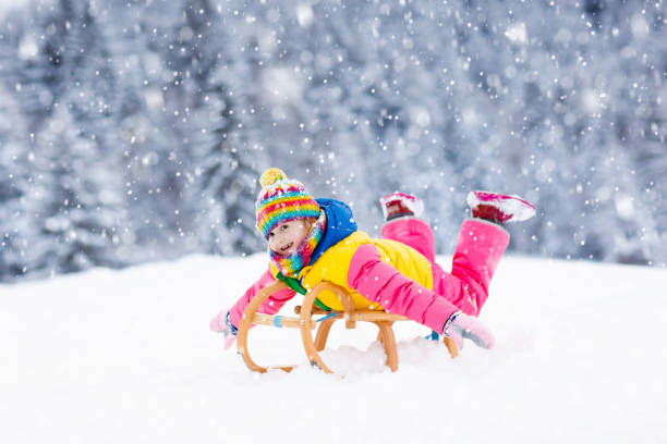 istock Girl on sleigh ride. Child sledding. Kid with sledge 1076229576