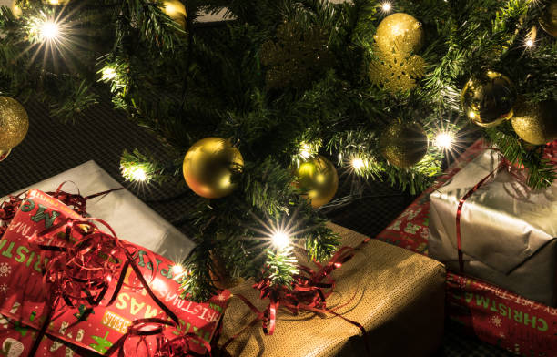istock colorful presents under a beautifully decorated Christmas tree with baubles and lights 1076234152