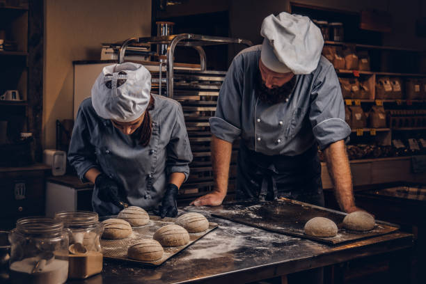 istock Cooking master class in bakery. Chef with his assistant showing ready samples of baking test in kitchen. 1076240150