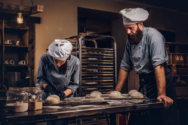istock Cooking master class in bakery. Chef with his assistant showing ready samples of baking test in kitchen. 1076241564