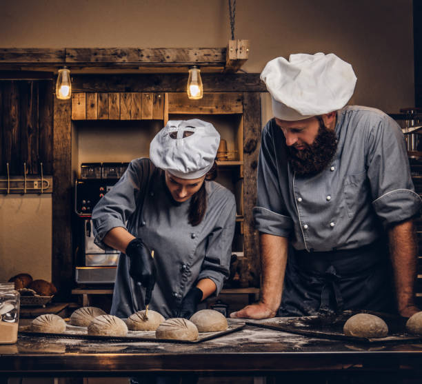 istock Cooking master class in bakery. Chef with his assistant showing ready samples of baking test in kitchen. 1076241972