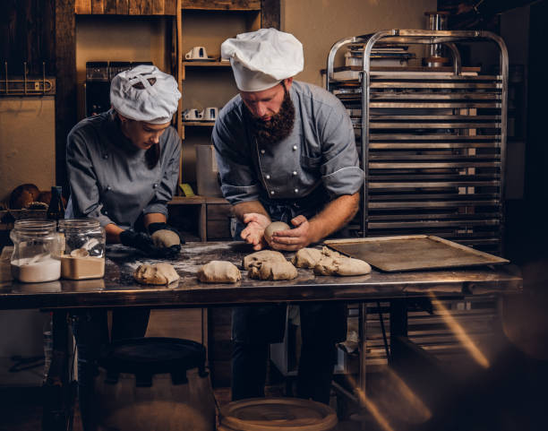 istock Chef teaching his assistant to bake the bread in a bakery. 1076242104