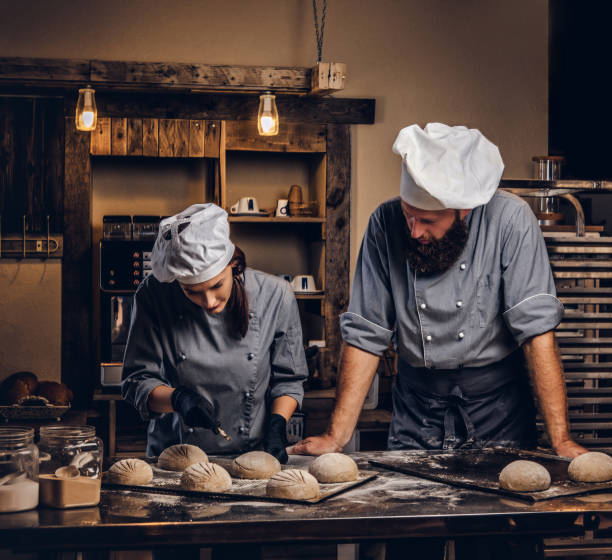 istock Chef teaching his assistant to bake the bread in a bakery. 1076242668