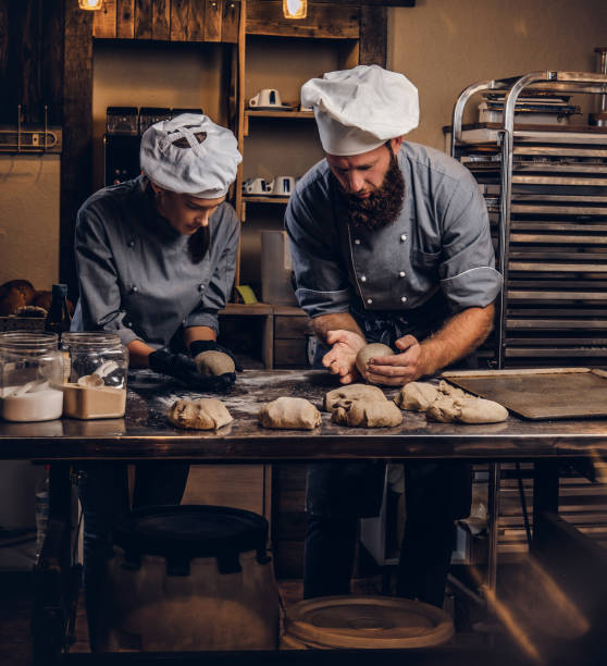 istock Chef teaching his assistant to bake the bread in a bakery. 1076242684