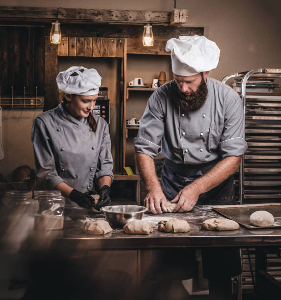 istock Chef teaching his assistant to bake the bread in a bakery. 1076243598
