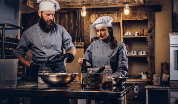 istock Chef teaching his assistant to bake the bread in the bakery. 1076248312