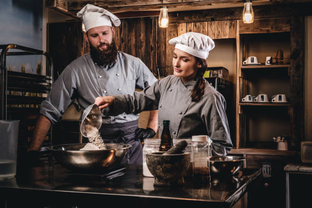 istock Cook assistant pours the flour into a bowl. 1076249318