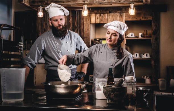 istock Cook assistant pours the flour into a bowl. 1076249544