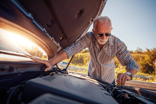 senior man checking the oil level - old men car oil imagens e fotografias de stock