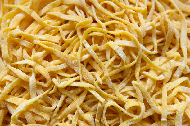 新鮮なパスタを新鮮な卵とデュラム小麦の粉から作られた ' フェットチーネと呼ばれます。 - wheat pasta flour italy ストックフォトと画像