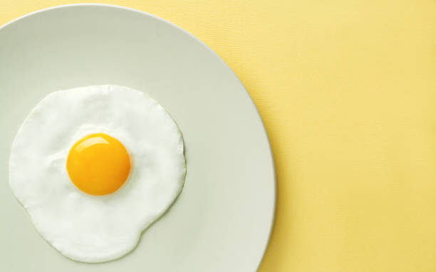 istock Top view of fried egg on yellow background 1076298480
