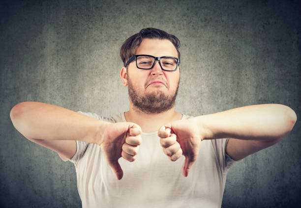 istock Dissatisfied chubby man showing thumbs down 1076309726