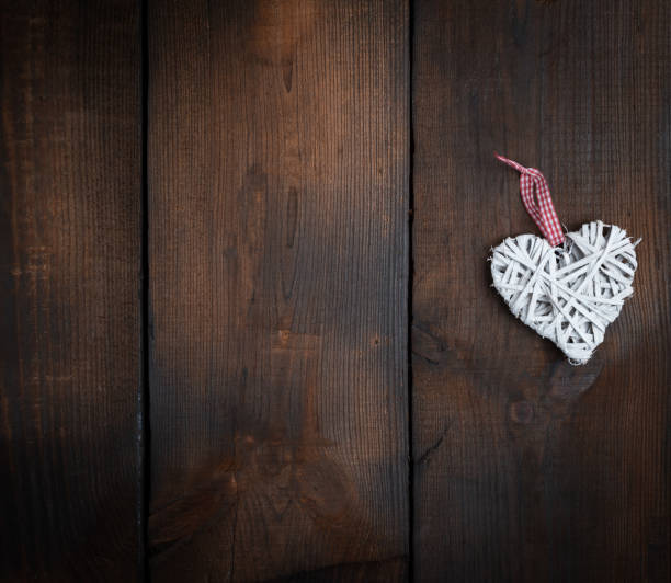 istock white wicker heart on a brown wooden plank background 1076315700