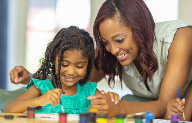 istock Girl painting with mother 1076322896