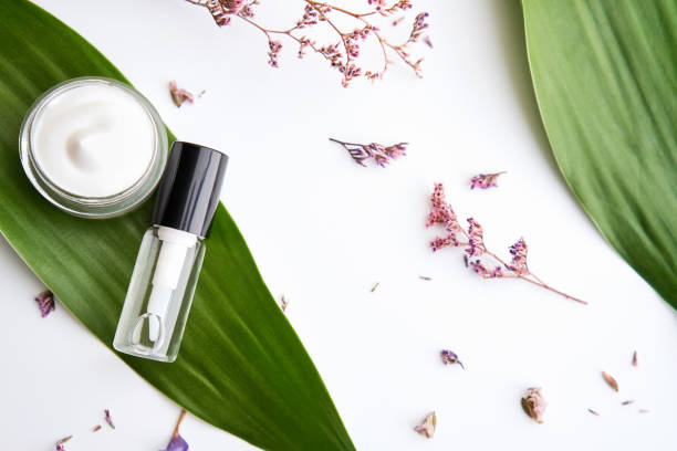 istock White cream bottle placed, Blank label package for mock up on a green foliage background and flowers. The concept of natural beauty products. 1076323924