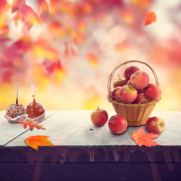 istock Old wooden table with apples and autumn leaves 1076324766