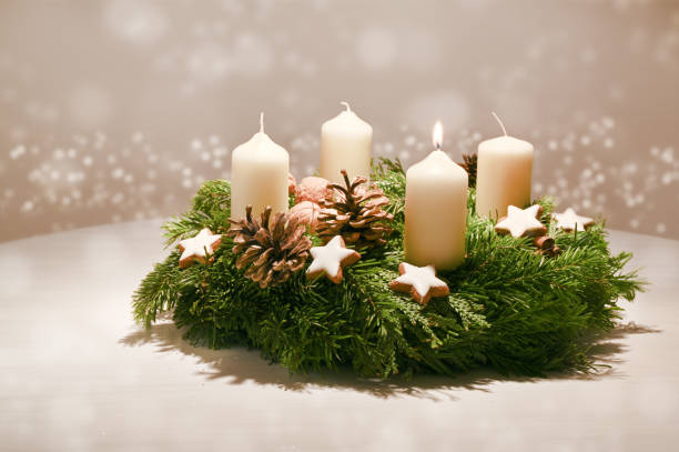 istock First Advent - decorated Advent wreath from fir and evergreen branches with white burning candles, tradition in the time before Christmas, warm background with festive bokeh and copy space 1076331358