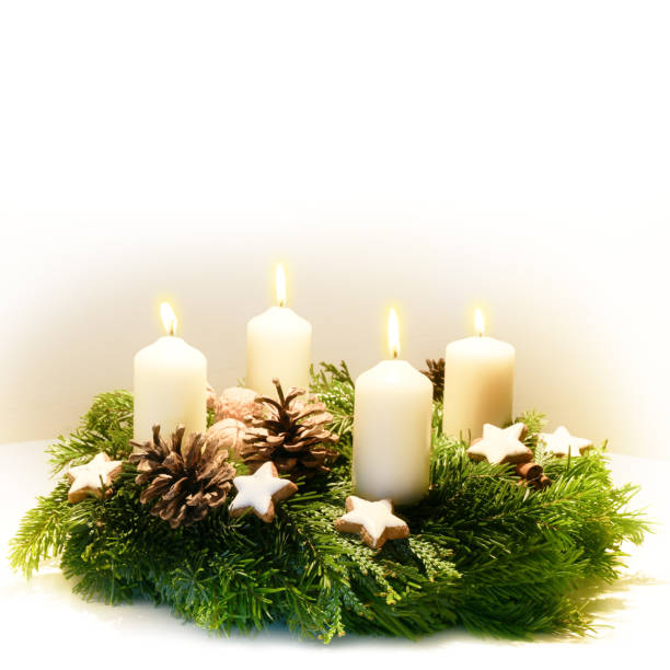 istock Decorated Advent wreath from fir and evergreen branches with burning white candles for the time before Christmas, the light background fades to white, copy space 1076332012