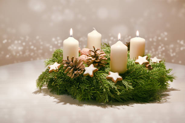 Third Advent - decorated Advent wreath from fir and evergreen branches with white burning candles, tradition in the time before Christmas, warm background with festive bokeh and copy space Third Advent - decorated Advent wreath from fir and evergreen branches with white burning candles, tradition in the time before Christmas, warm background with festive bokeh and copy space, selected focus advent candles stock pictures, royalty-free photos & images