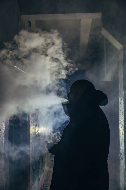 istock Smoking or vaping man silhouette in dark gloomy corridor 1076341728