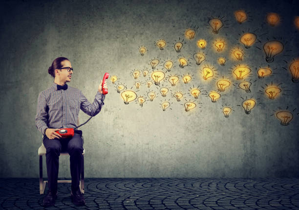 istock business man holding red telephone spreading brilliant ideas 1076354902