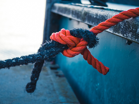 Two different colored ropes tied together at a mooring