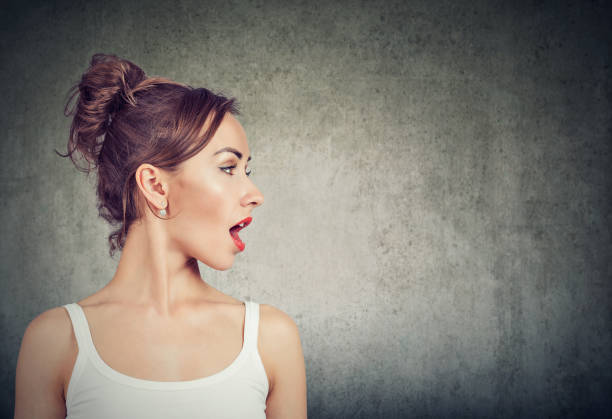 istock Closeup side view profile portrait woman talking with open mouth 1076359824