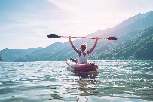 Happy woman loving canoeing on lake in Summer