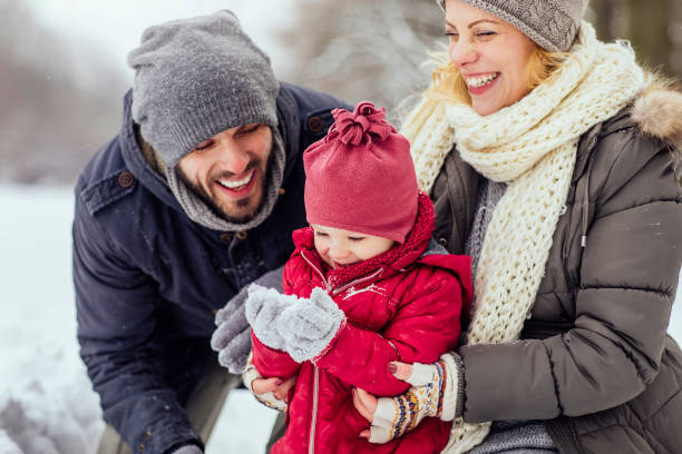 Young family playing with snow in the park