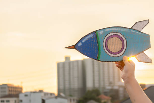 istock STEM Education concept. Kids are holding a rocket paper. 1076398186
