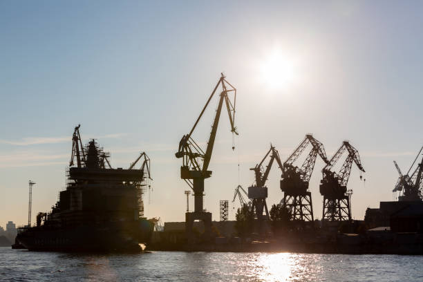 istock Silhouette shipyard have crane machine, Shipyard industry. 1076406084