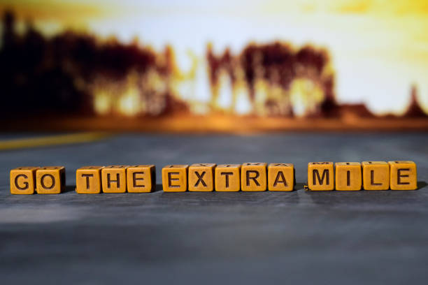 Go the extra mile on wooden blocks. Go the extra mile on wooden blocks. Cross processed image with bokeh background dedication stock pictures, royalty-free photos & images