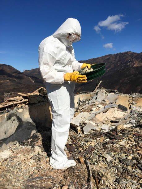 istock Man in Hazmat Suit Sifting Through Wildfire Ash/Waste 1076431344