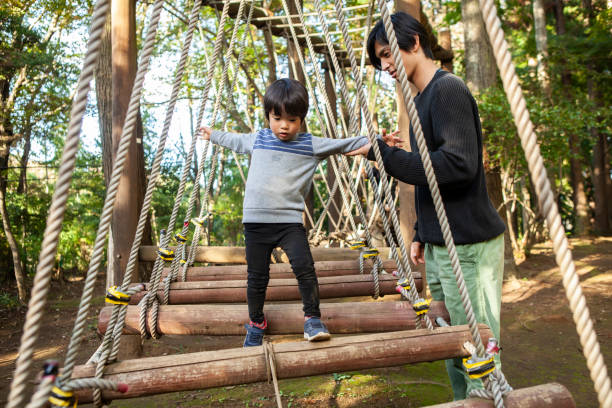 istock A child playing with a park and a suspended bridge type playground. 1076446384