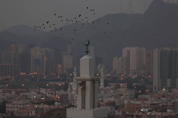 Birds flying around the minaret in Mecca Birds flying around the minaret in Mecca hyderabad pakistan stock pictures, royalty-free photos & images