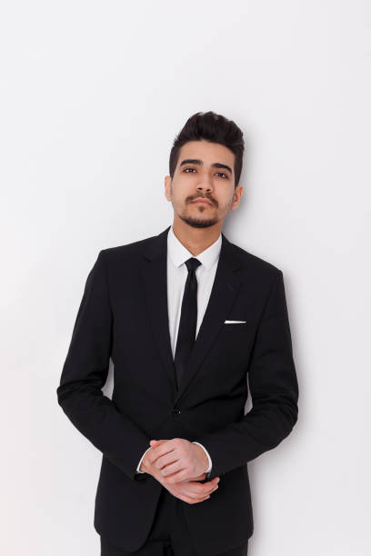 istock Young businessman in black suit on a white background 1076471254
