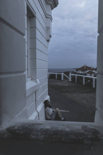 istock Woman sitting near wall on pavement 1076480636