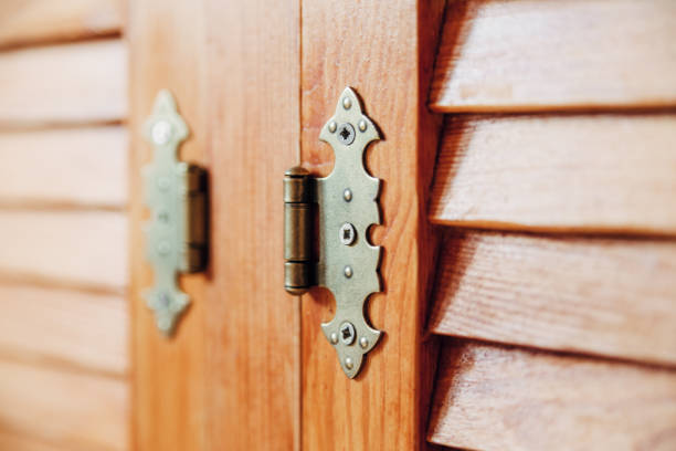 istock louvered wooden doors.iron hinge.brown yellow color.close-up view 1076480962