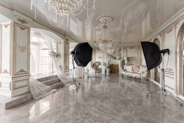 istock Photo Studio interior. classic luxurious apartments with a white fireplace, sofa, large windows and chandelier. 1076482954