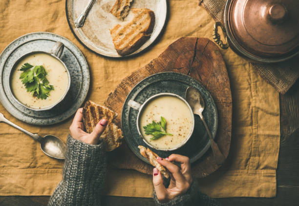 istock Celery cream soup and female hands with grilled bread 1076485918