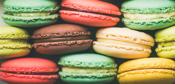 istock Colorful French macaroons cookies stacked in rows, wide composition 1076486406