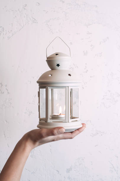 istock Woman holding a Christmas lantern on a white wall background 1076496768