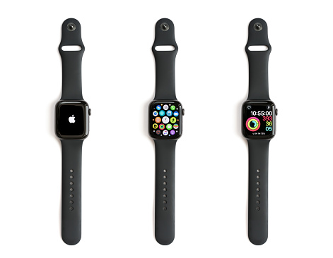 Celje, Slovenia - November 28, 2018: Three 44 mm Space Gray Aluminium Apple Watches, series 4 with black sports band and different clock faces (Apple logo, mobile apps and Activity app). Isolated on white background.