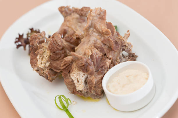 Turkey necks,  served with horseradish puree,  placed on white plate,  light background,  isolated