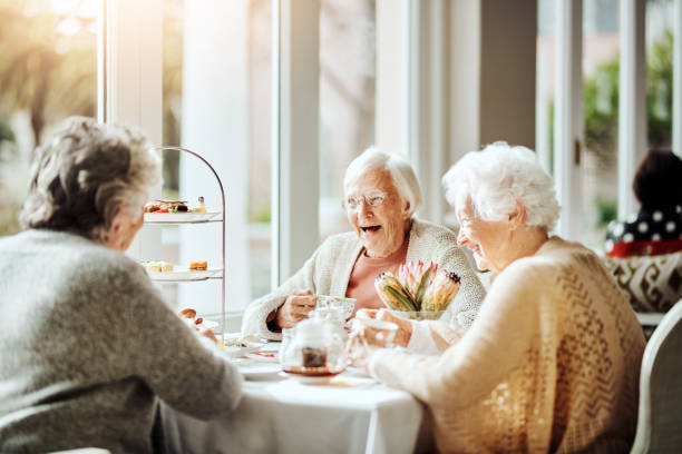 есть н�есколько вещей, более приятным, чем чай с друзьями - afternoon tea tea women table стоковые фото и изображения