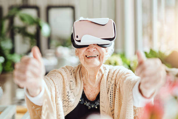 ce qui porte le monde extérieur à l’intérieur avec la réalité virtuelle - senior adult leisure games playing care photos et images de collection