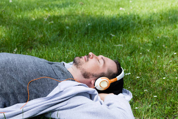 istock Relaxing on spring grass with music over headphones. 1076511494